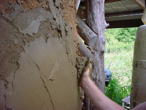 hand applying mud plaster